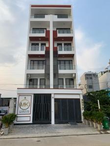 um edifício alto com uma garagem em frente em MK Studio - Liên Phuong - District 9 em Ho Chi Minh