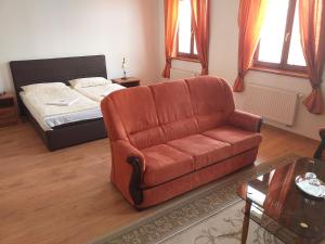 a living room with a couch and a bed at Penzion Scarlet in Trenčín