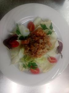 eine weiße Platte mit Salat und Tomaten in der Unterkunft Guest House in Parabita