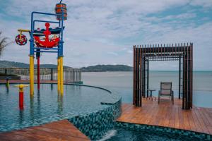 a pool with a gate and a table and chairs in the water at Swiss-Belhotel Kuantan in Kuantan