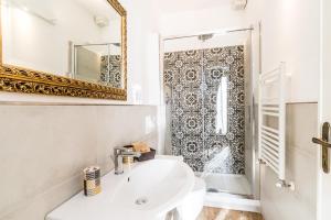 uma casa de banho com um lavatório, um espelho e um chuveiro em B&B Grano e Lavanda em Greve in Chianti