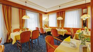 a restaurant with tables and chairs in a room at Hotel am Schelztor in Esslingen