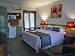 a bedroom with a large bed and a kitchen at Adamsons Riverside Accommodation in Margaret River Town