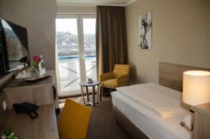 a hotel room with a bed and a large window at Hotel Morjan in Koblenz