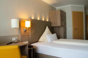 Habitación de hotel con cama y silla amarilla en Hotel Morjan, en Coblenza