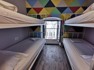 スプリトにあるFiesta Siesta Social Hostelのカラフルな壁の客室で、二段ベッド2組が備わります。