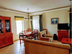 - un salon avec un canapé, une table et des chaises dans l'établissement TripGeo Pinhal da Aroeira Villa, à Almada