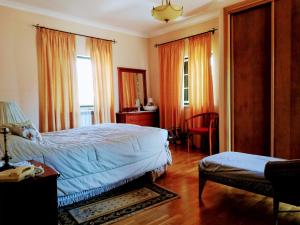 - une chambre avec un lit, une chaise et une fenêtre dans l'établissement TripGeo Pinhal da Aroeira Villa, à Almada