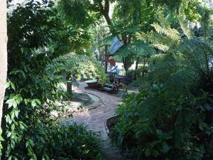 a garden with a bench in the middle of trees at Adamsons Riverside in Margaret River Town