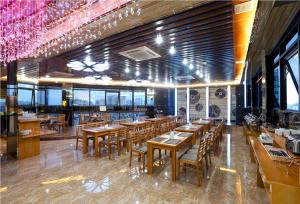 a restaurant with wooden tables and chairs and windows at Au Viet Hotel in Hanoi