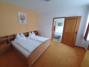 ein Schlafzimmer mit einem großen Bett und einer Tür in der Unterkunft Appartement Roiss in Podersdorf am See