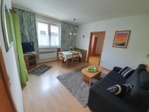 un soggiorno con divano e tavolo di Appartement Roiss a Podersdorf am See