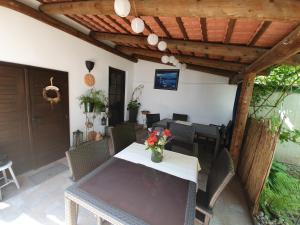 eine Terrasse mit einem Tisch und Stühlen sowie einer hölzernen Pergola in der Unterkunft Appartement Roiss in Podersdorf am See