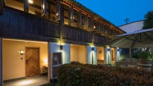 a building with a wooden door and an umbrella at Floral Hotel · Yuexiang Inn Wuzhen in Tongxiang