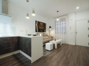 uma cozinha e uma sala de estar com um sofá em Arjona Suite Apartment em Sevilha