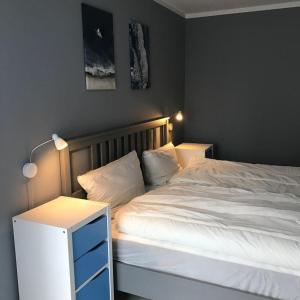 een slaapkamer met een wit bed en een nachtkastje bij Ferienwohnung-Hafenmeisterei in Orth