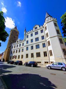 un gran edificio blanco con coches estacionados frente a él en alte Bäckerei Bautzen - 01 #Family# en Bautzen