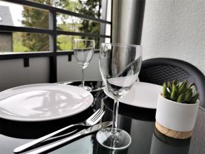 a table with two wine glasses and plates on it at Loft Luis - Bikepark & Skilift - in Winterberg