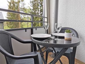 einen Tisch und Stühle mit Weingläsern auf dem Balkon in der Unterkunft Loft Luis - Bikepark & Skilift - in Winterberg