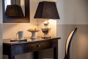 Hotel Lido في ألاسيو: طاولة عليها مصباح وصحن من الطعام