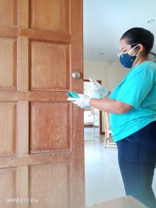 a woman wearing a mask and gloves and a door at AnB poolvilla 2BR with private beach in pratamnak in Pattaya South