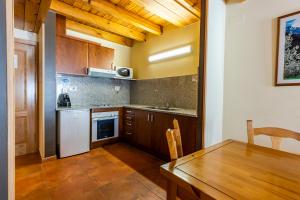 een keuken met een houten tafel en een eetkamer bij Apartaments Sant Moritz in Arinsal