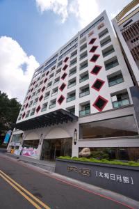 un gran edificio blanco con plazas rojas. en Taihe sun and the moon hostel en Yuchi