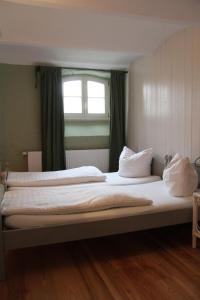 a large bed in a room with a window at Gutshaus Thorstorf FeWo Boltenhagen in Warnow