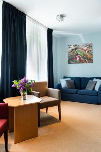 a living room with a couch and a table at Hotel Nawigator Szczawnica in Szczawnica