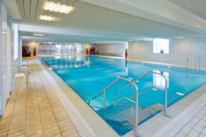 uma grande piscina interior com água azul em Gesundheitszentrum Helenenquelle em Bad Wildungen