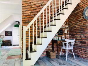 - un mur en briques et des escaliers dans une chambre avec une table et une chaise dans l'établissement Apartament Konopnickiej, à Świnoujście