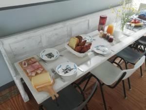 B&B de Hoop في فوركوم: طاولة بيضاء عليها طبق من الطعام