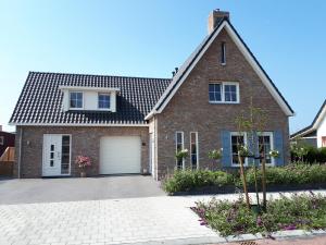 uma casa de tijolos com garagem em De Sprink - Vakantiewoning em Zoutelande