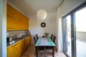 a kitchen with a table with chairs and a sink at Villa Medusa in Lucija