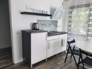 a kitchen with a black and white cabinet and a table at City Apartment, 27 qm, 2 Personen, high Sp WLAN in Paderborn +5 photos
