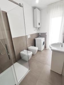 a bathroom with a shower and a toilet and a sink at Maredena in Lido di Jesolo
