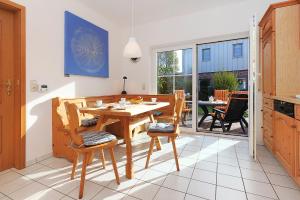 uma cozinha com uma mesa de madeira e cadeiras num quarto em Jever-Ferienhaus Gartenblick em Jever