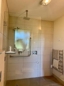 a shower with a glass door in a bathroom at Teviot View Accommodation in Amberley