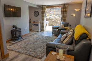 uma sala de estar com um sofá e um fogão em Croft Cottage em Skelsmergh