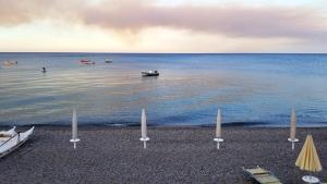 a beach with some boats in the water at casa delle mimose in Cardedu