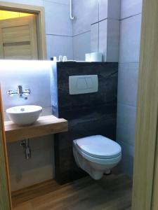 a bathroom with a white toilet and a sink at A&P Motel in Mikołów