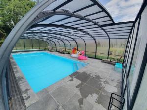a swimming pool under an archway over a swimming pool at Gîtes de Maner Ster - Le Frêne Piscine ou Le Chêne Piscine in Cléden-Poher