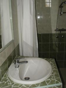 a white sink in a bathroom with a shower at Balla Appartements in Zalakaros