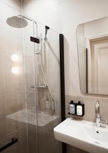 uma casa de banho com um chuveiro e um lavatório. em The Times Hotel em Amsterdã