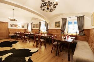 a dining room with tables and chairs and a chandelier at Landgasthof Karner in Frasdorf