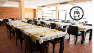 une salle à manger avec des tables, des chaises et un panneau dans l'établissement Hotel Rural Santo Antonio, à Arronches