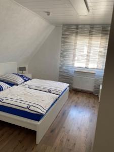 um quarto com uma cama e uma janela em Ferienwohnungen Thingslinde em Kierspe