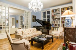 Una sala de estar con un sofá y un piano. en Chateau de Moison, Domaine Eco Nature, en Ivoy-le-Pré