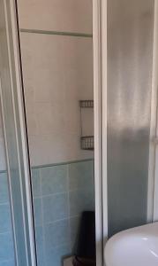 リド・ディ・イエゾロにあるRESIDENCE GALLO - WALTERIGATO Apartments PER SOLO FAMIGLIEのトイレの隣にガラスドア付きのシャワーが備わります。