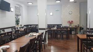 a dining room with tables and chairs and a clock on the wall at Słoneczna in Miedzygorze